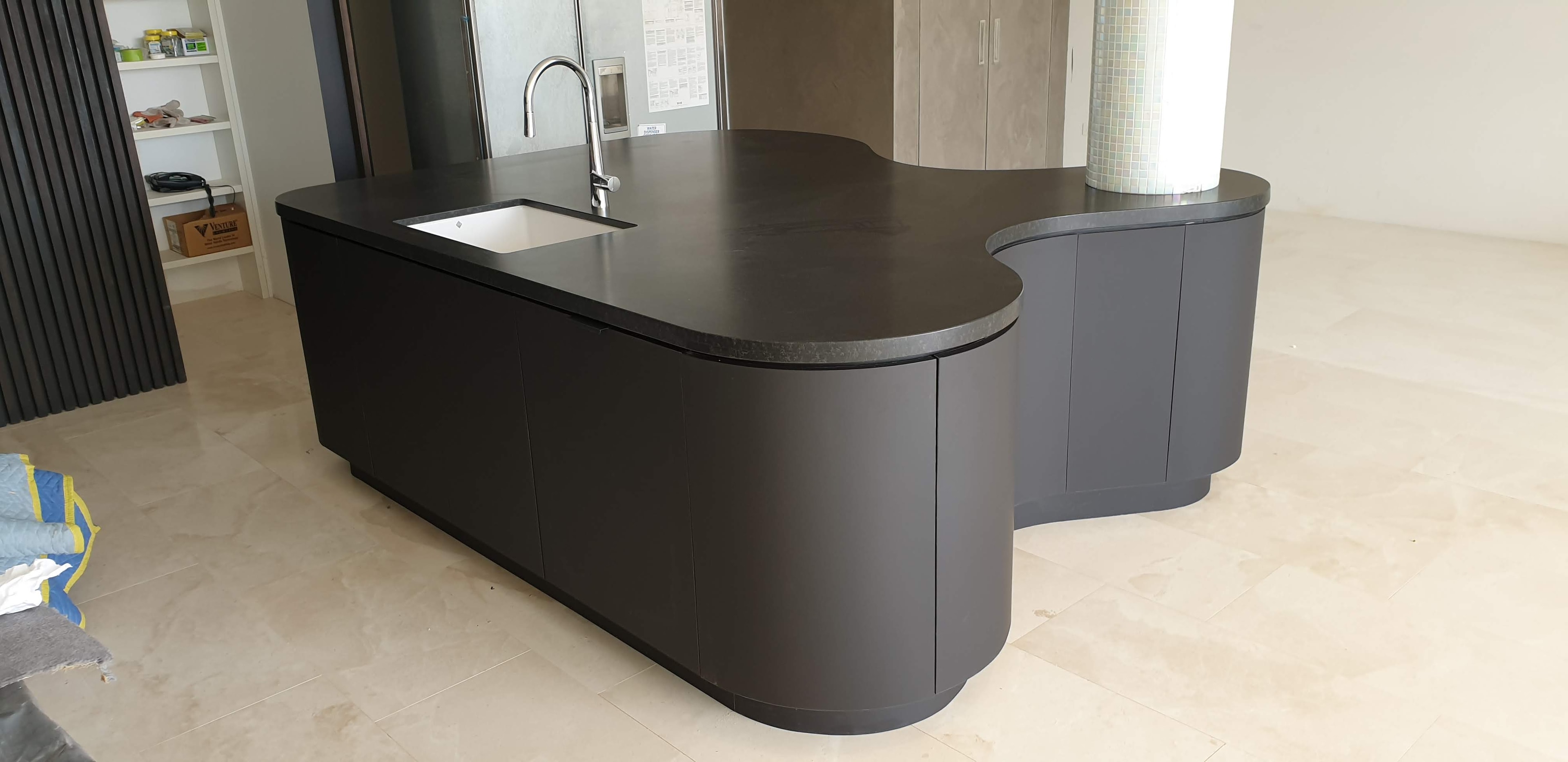 Curved dark charcoal kitchen island with stone benchtop